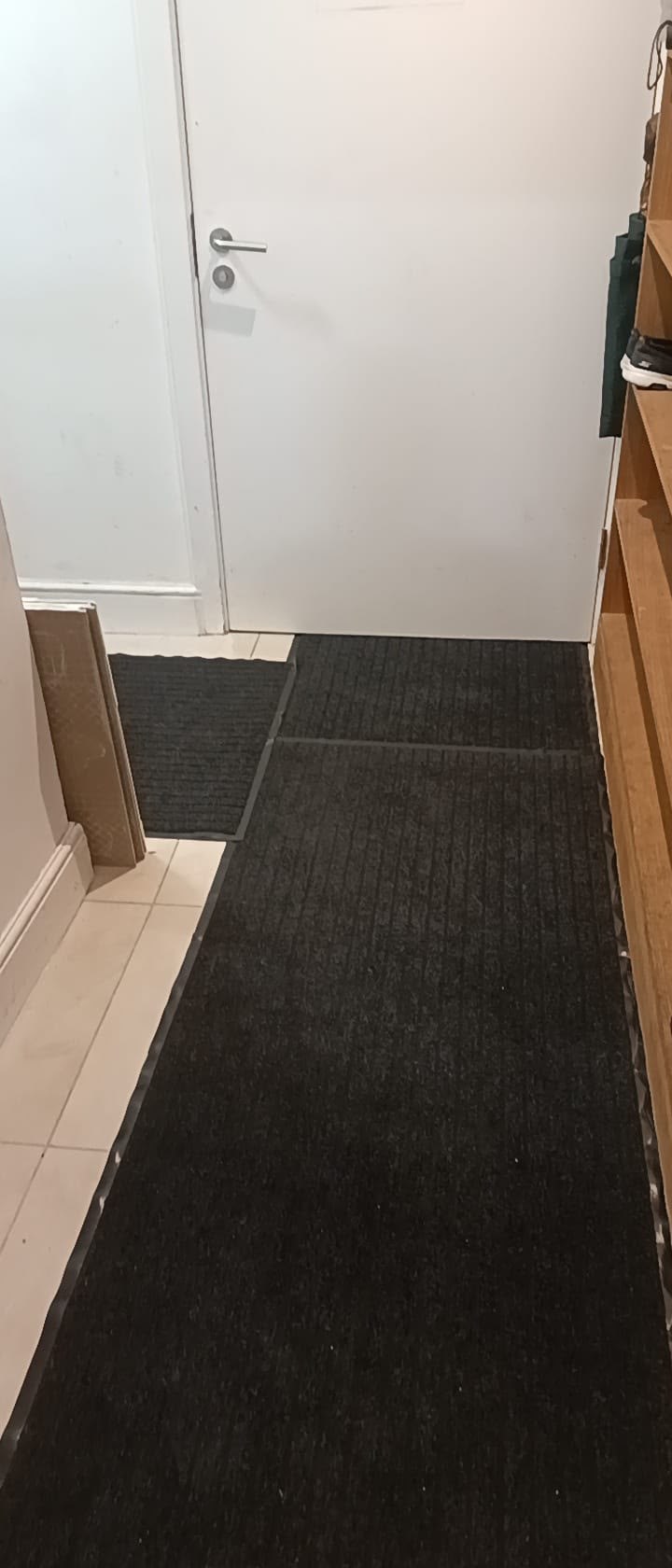 The mosque hallway after it was cleared and covered with a continuous dark floor runner